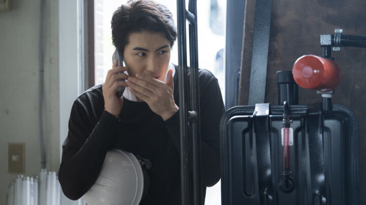 An employee secretly talking on the phone in a warehouse