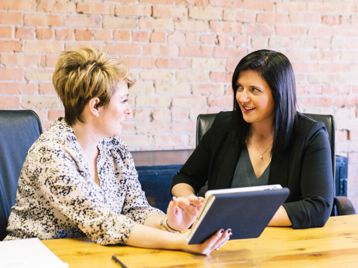 Two colleagues who seem to be in an informal conversation in the office