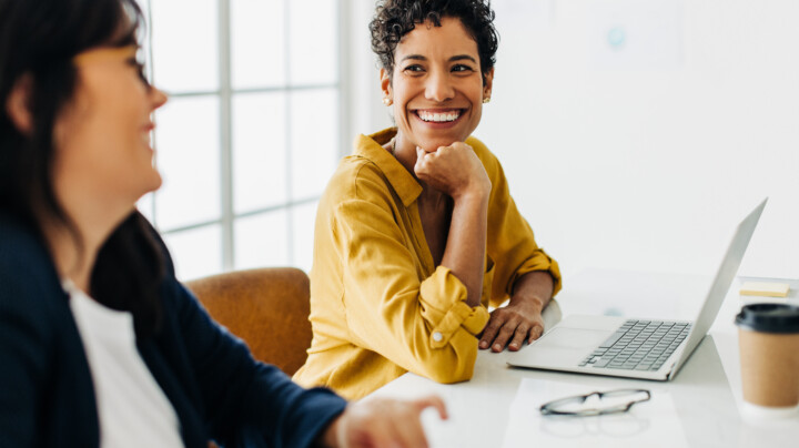 Happy business woman talking to her colleague in a meeting