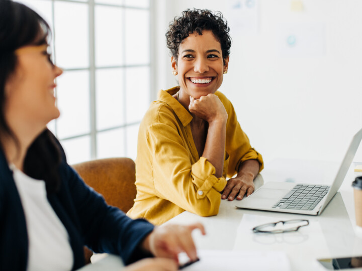 Happy business woman talking to her colleague in a meeting