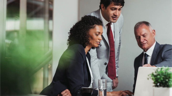 Three diverse employees working collaboratively in the office.