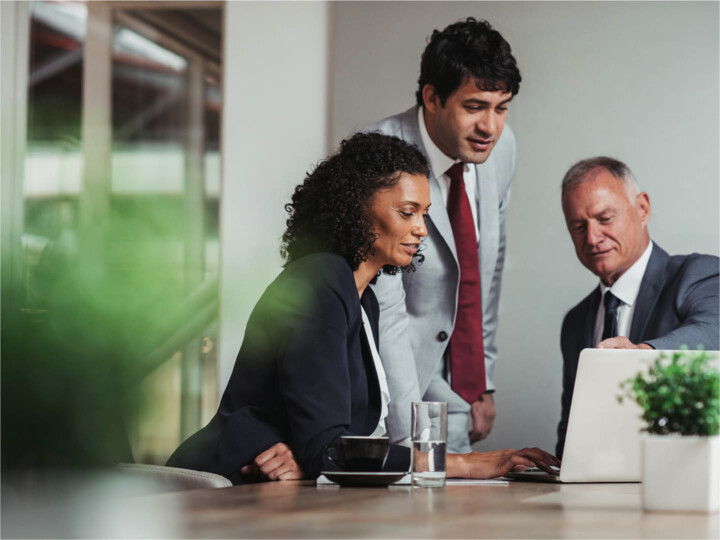 Three diverse employees working collaboratively in the office.