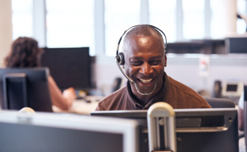 A happy employee in a virtual meeting while being in the office.
