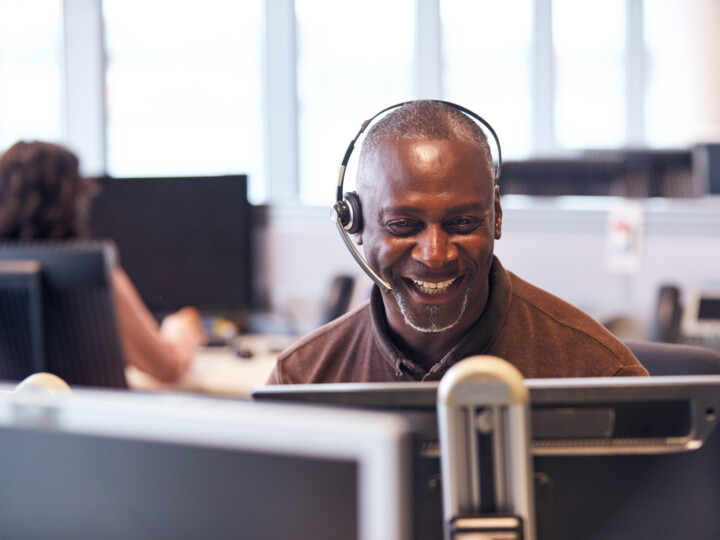 A happy employee in a virtual meeting while being in the office.