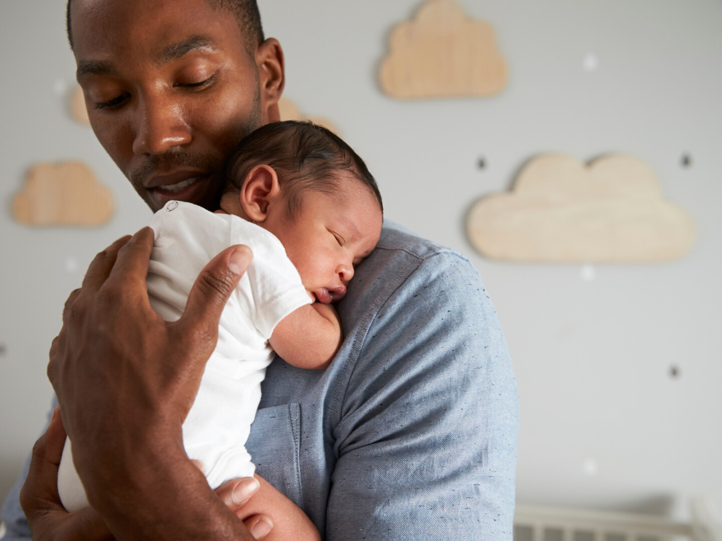 Father holding a newborn baby in the nursery