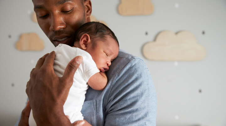 Father holding a newborn baby in the nursery