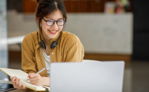 A happy young female employee working from home