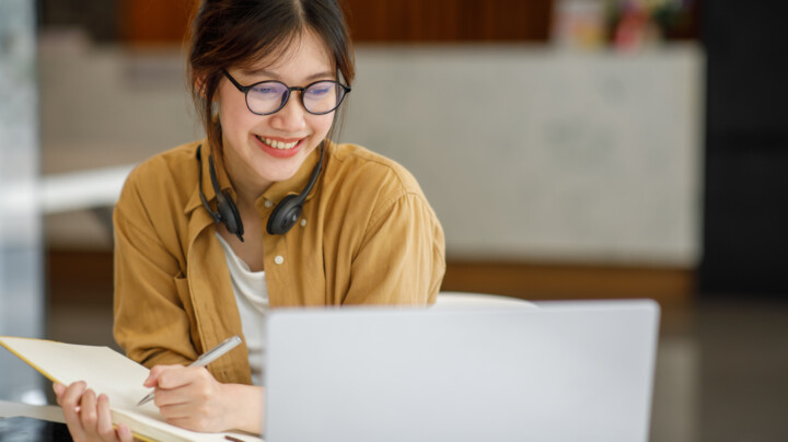 A happy young female employee working from home