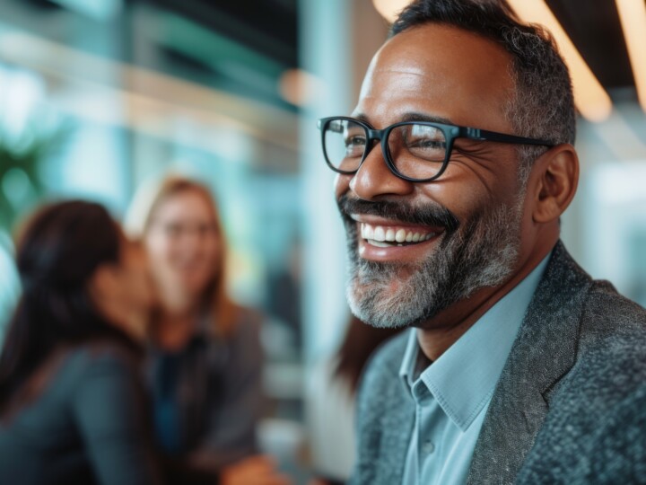 Mature businessman smiling while being among his colleagues