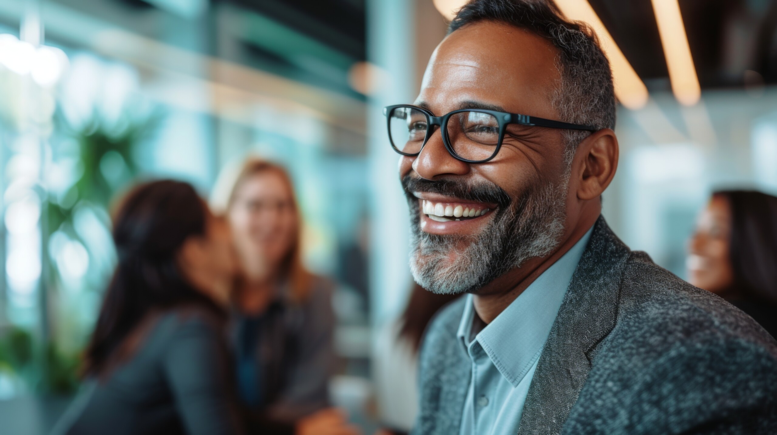 Mature businessman smiling while being among his colleagues
