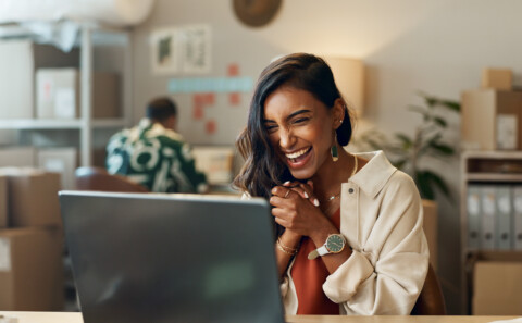 Woman excitedly looking at her laptop screen
