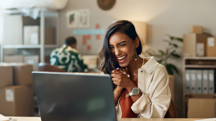 Woman excitedly looking at her laptop screen