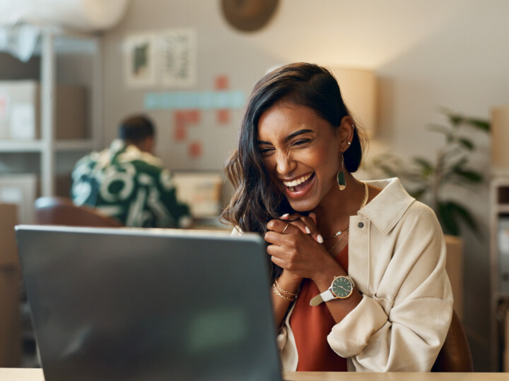 Woman excitedly looking at her laptop screen