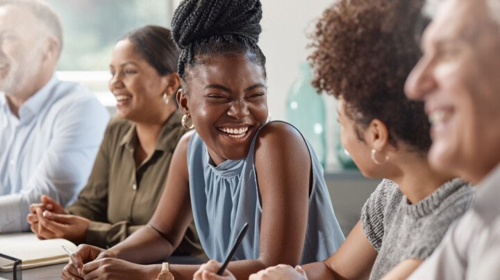 A group of employee laughing in a meeting