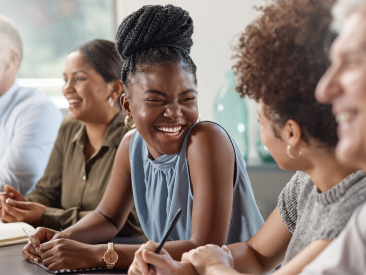 A group of employee laughing in a meeting