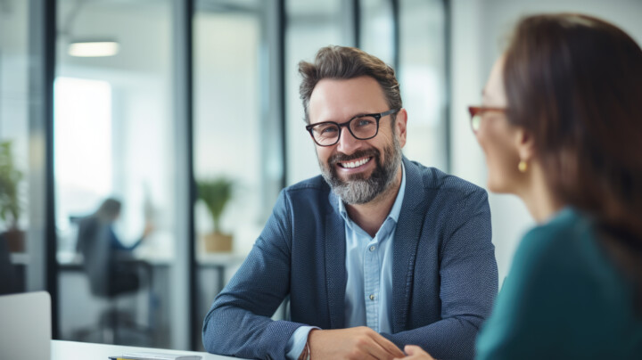 Happy business professional in a 1-2-1 with a happy female employee