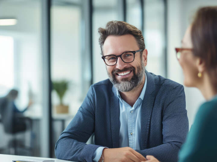 Happy business professional in a 1-2-1 with a happy female employee