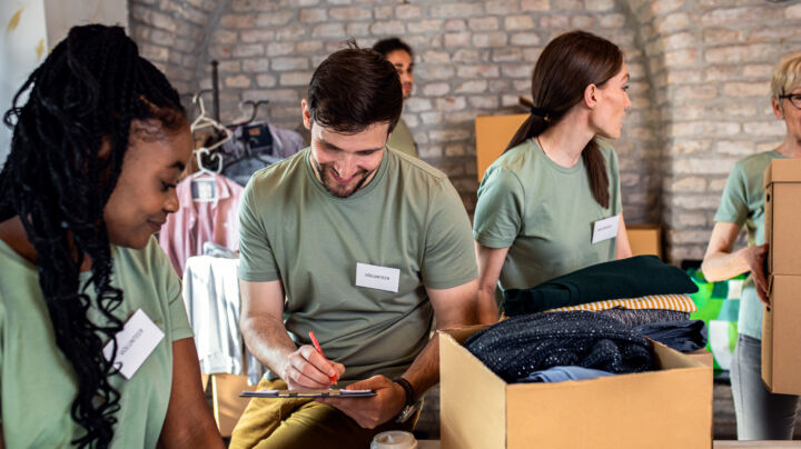 Group of volunteers working in community charity donation center.